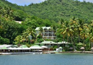 An all-inclusive resort on a tropical island adorned with lush palm trees is nestled in the scenic beauty of St. Lucia.