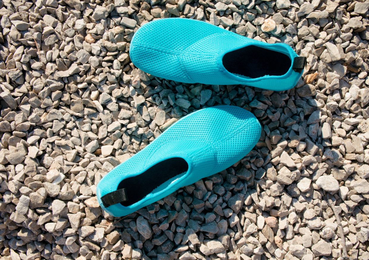 A pair of blue flip flops resting on gravel during a St. Lucia vacation.