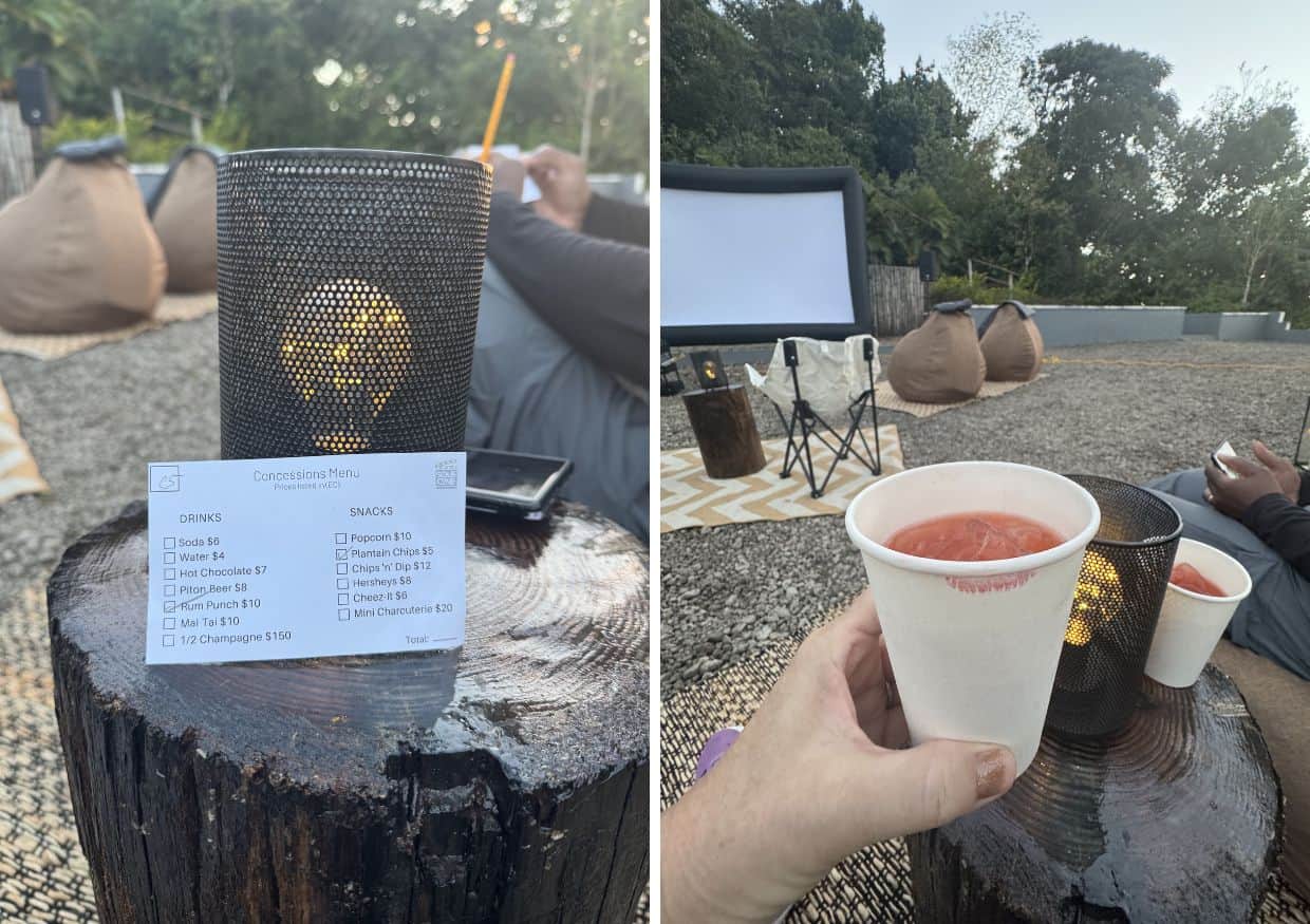 Experience a St. Lucia cinema like never before with an outdoor movie setup, boasting a charming menu and drinks on a tree stump. Settle into cozy bean bags as an inflatable screen lights up the night sky, with two cups held warmly in the foreground.